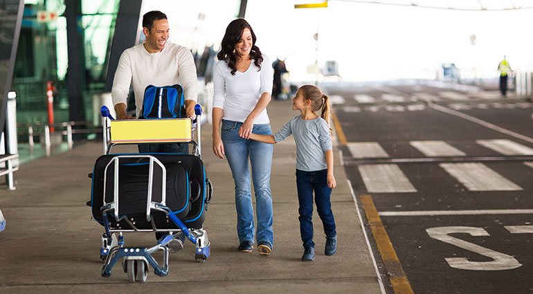 Family walking at airport with luggage