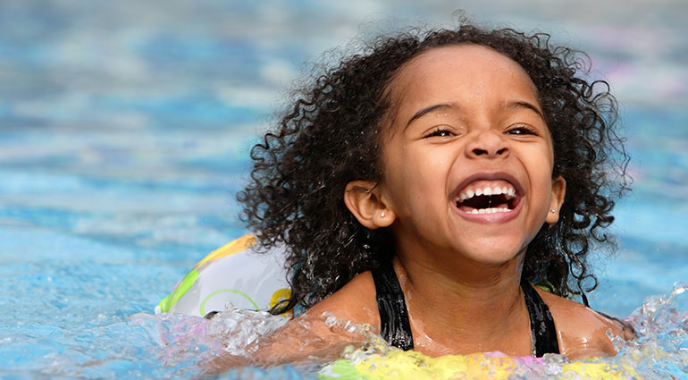 A kid playing in the pool