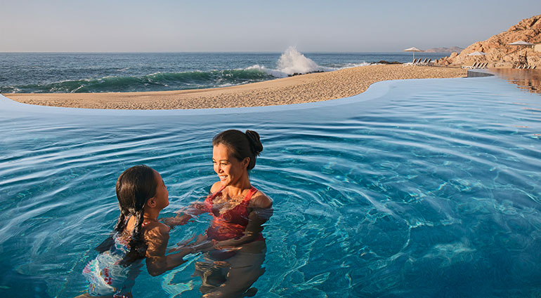 A mother and daughter play in an infinity pool at The Westin Los Cabos Resort Villas & Spa